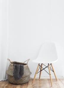 Skalbiniai skalbinių krepšyje minimalistinio stiliaus kambaryje.